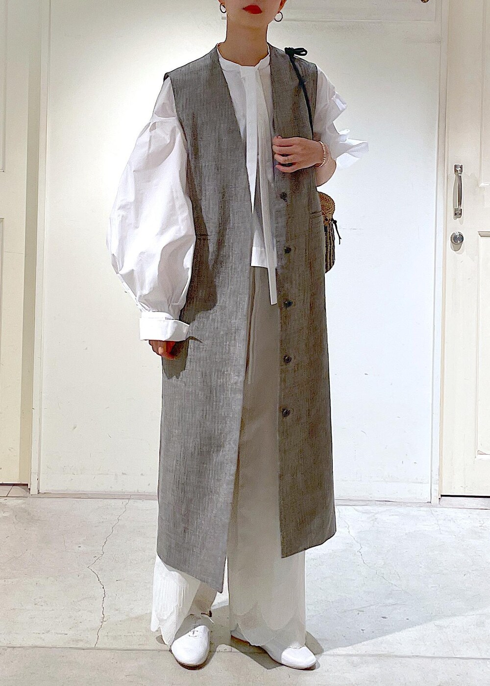ホワイト系のシャツ/ブラウス、ホワイト系のその他シューズ、ブラック系のジャンパースカートを着用したレディースの冬コーディネートの4枚目の写真