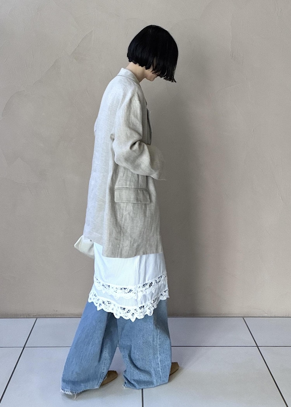 イエロー系のその他シューズ、ベージュ系のテーラードジャケット、ブルー系のデニムパンツを着用したレディースの冬コーディネートの6枚目の写真