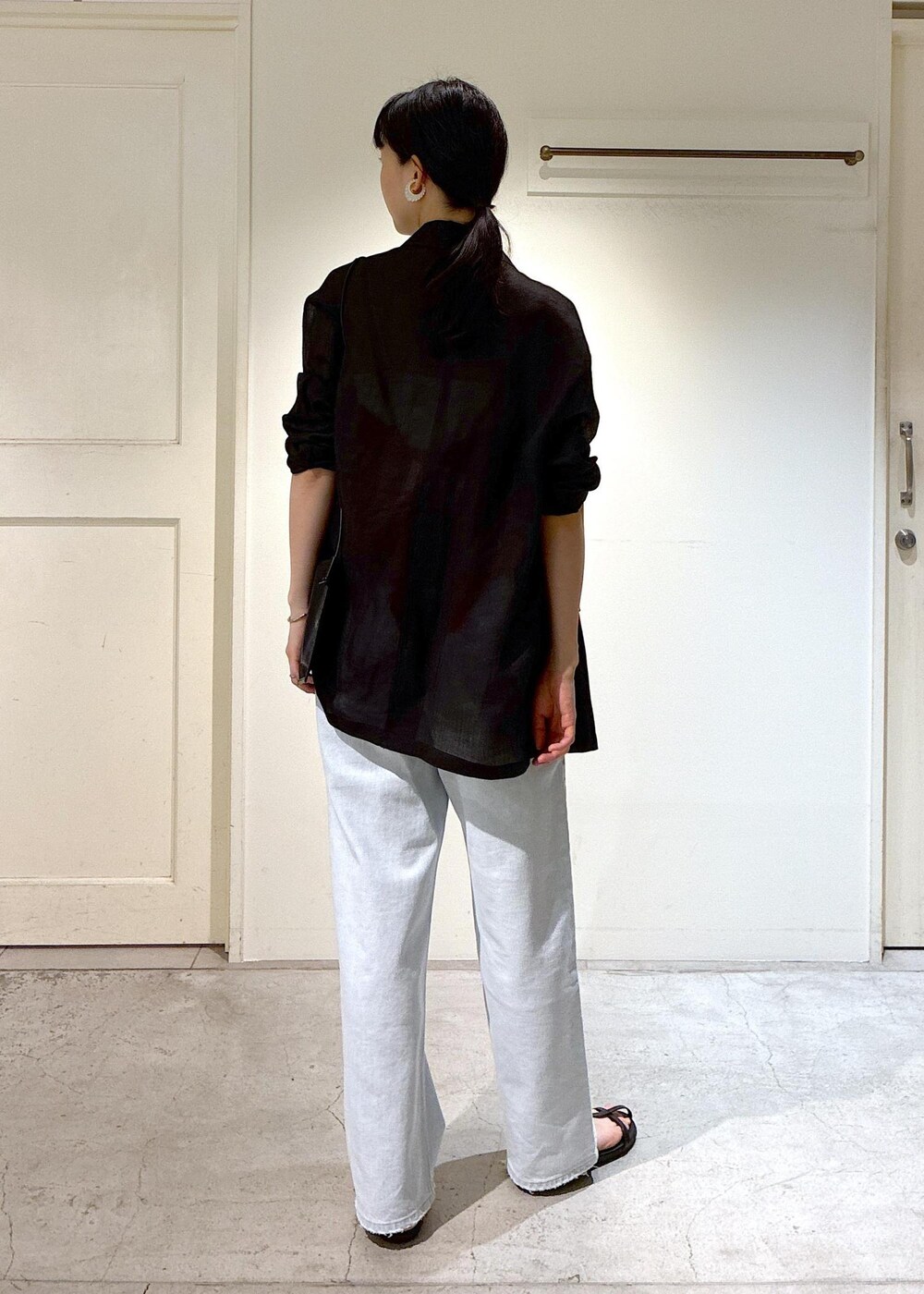 ブルー系のデニムパンツ、ブラック系のサンダル、グレー系のテーラードジャケットを着用したレディースの夏コーディネートの3枚目の写真