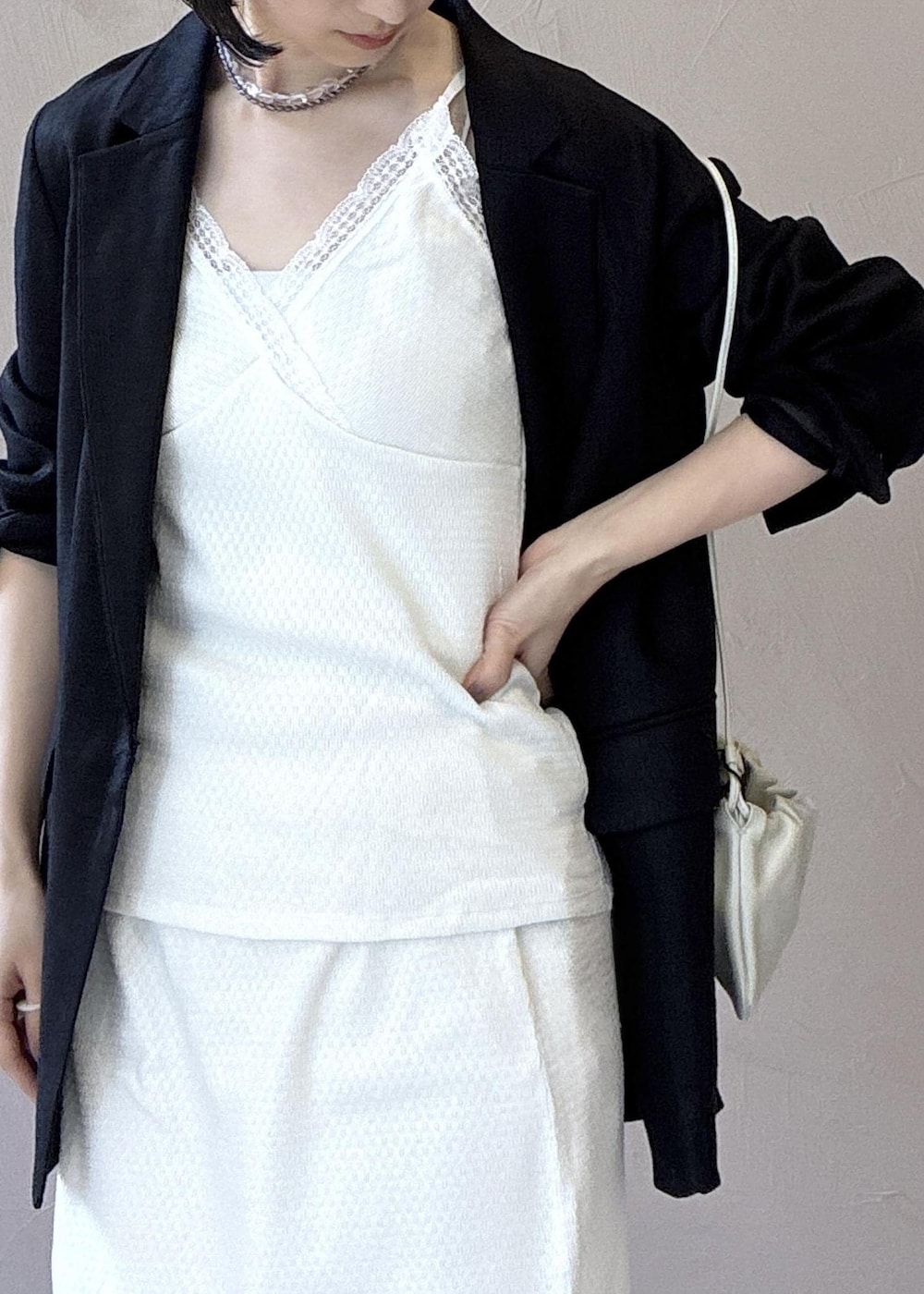 ブラック系のテーラードジャケット、ブラック系のサンダル、ホワイト系のキャミソールを着用したレディースの春コーディネートの8枚目の写真