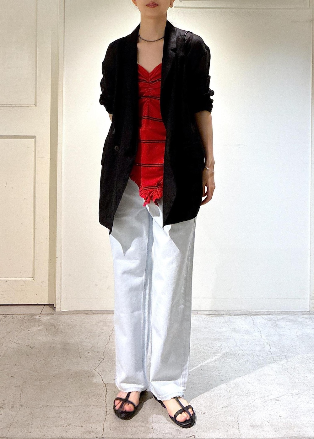 ブルー系のデニムパンツ、ブラック系のサンダル、グレー系のテーラードジャケットを着用したレディースの夏コーディネートの4枚目の写真