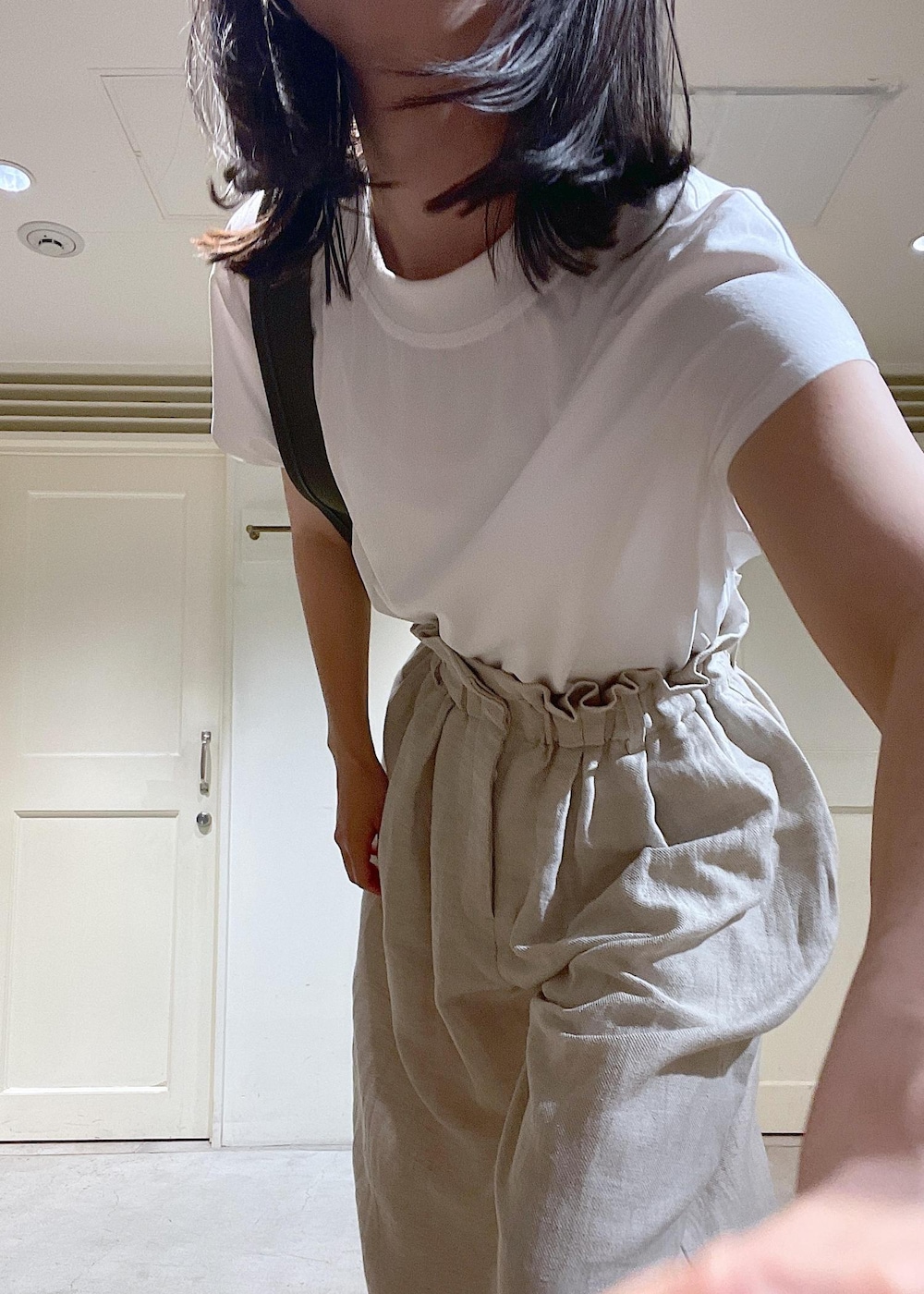 ブラック系のサンダル、グレー系のスラックス、ホワイト系のTシャツ/カットソーを着用したレディースの春コーディネートの7枚目の写真