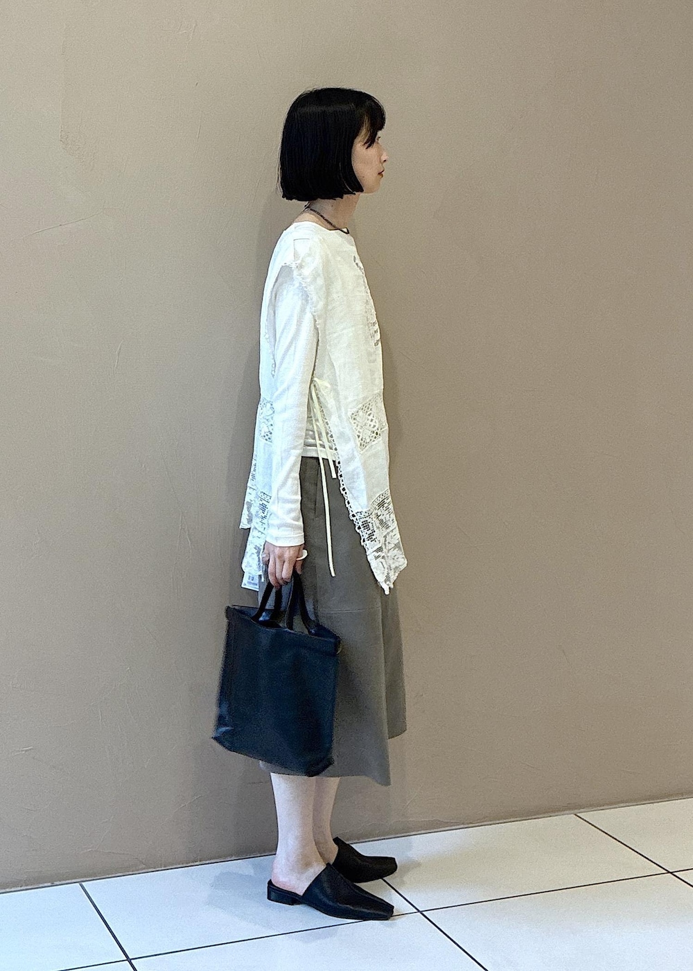 ホワイト系のTシャツ/カットソー、ブラック系のその他シューズ、ベージュ系のその他パンツを着用したレディースの春コーディネートの3枚目の写真