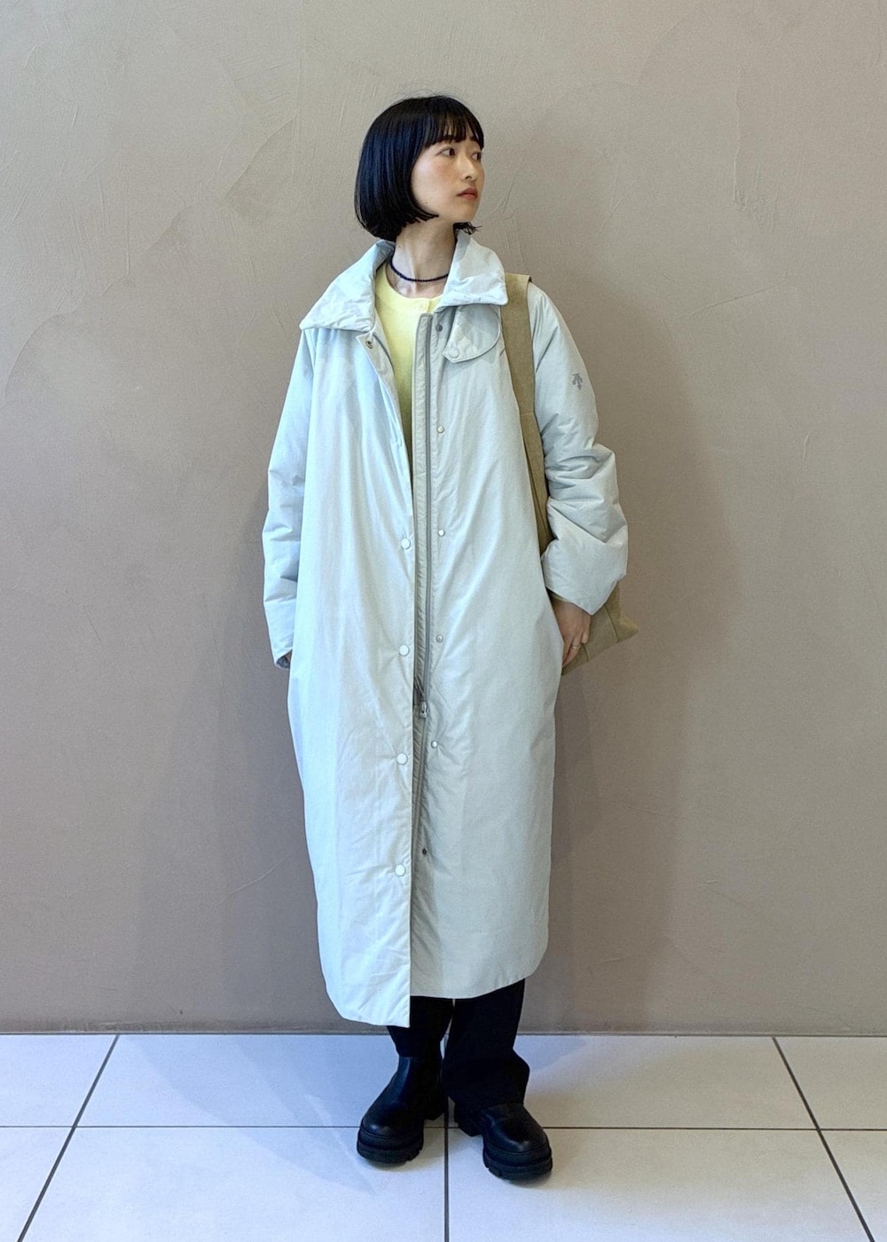 ブラック系のブーツ、ベージュ系のショルダーバッグ、グレー系のカーディガン/ボレロを着用したレディースの秋コーディネートの2枚目の写真