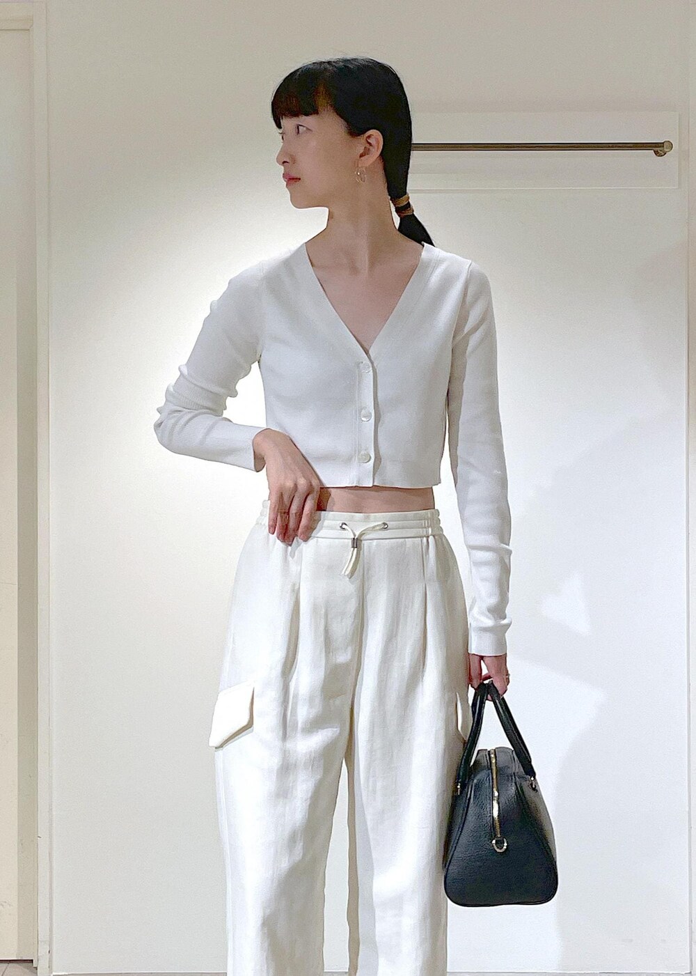 ホワイト系のキャミソール、ホワイト系のカーディガン/ボレロ、ホワイト系のカーゴパンツを着用したレディースの夏コーディネートの3枚目の写真