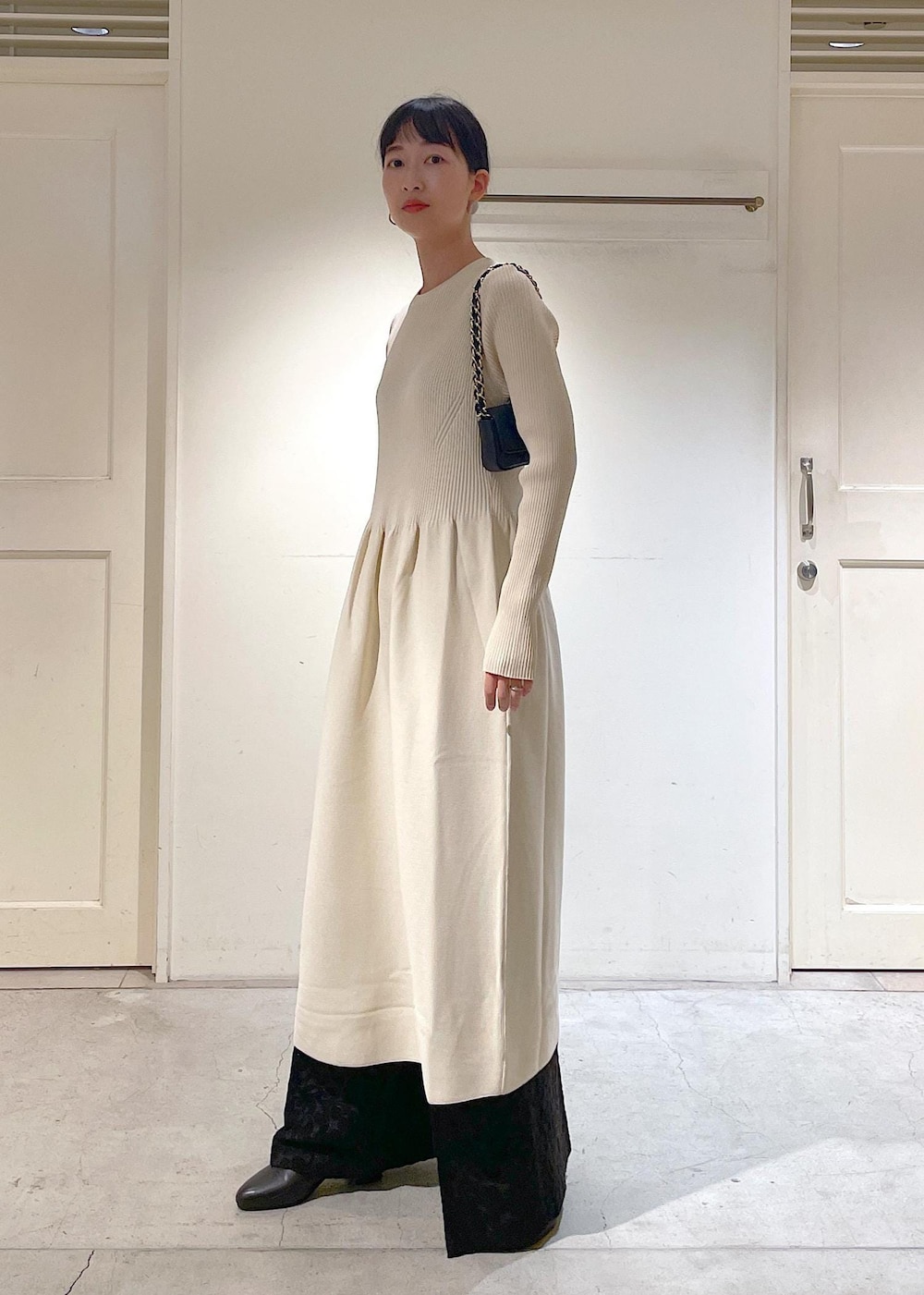 ブラック系のショルダーバッグ、ブラック系のブーツ、ブラック系のその他パンツを着用したレディースの冬コーディネートの2枚目の写真