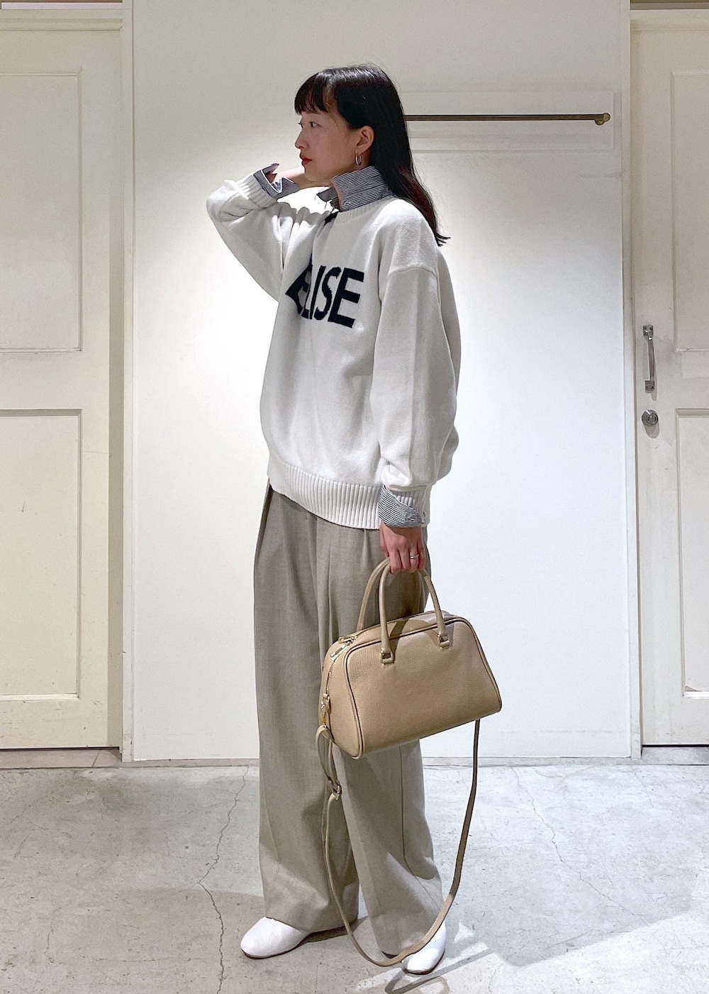 ホワイト系のその他シューズ、ブルー系のシャツ/ブラウス、ベージュ系のスラックスを着用したレディースの冬コーディネートの3枚目の写真