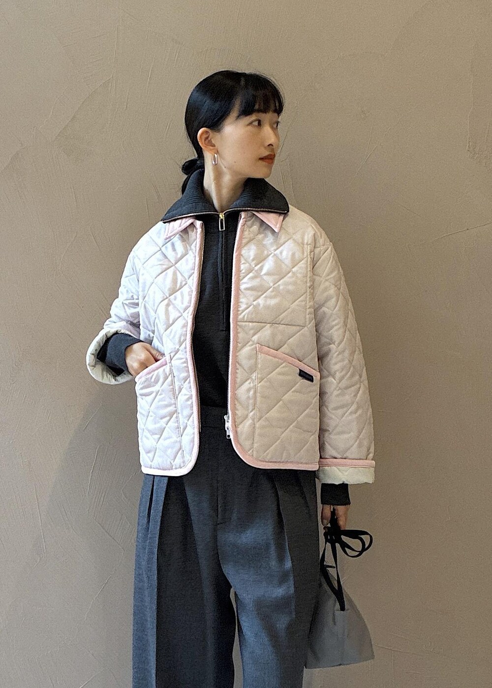 グレー系のスラックス、グレー系のニット/セーター、ピンク系のブルゾンを着用したレディースの秋コーディネートの6枚目の写真