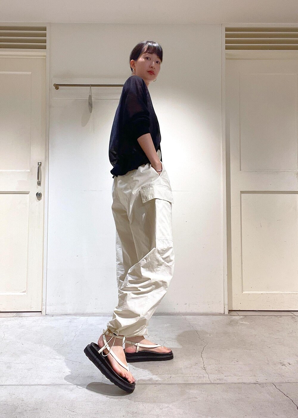 ブラック系のカーディガン/ボレロ、ホワイト系のカーゴパンツ、ホワイト系のサンダルを着用したレディースの夏コーディネートの6枚目の写真