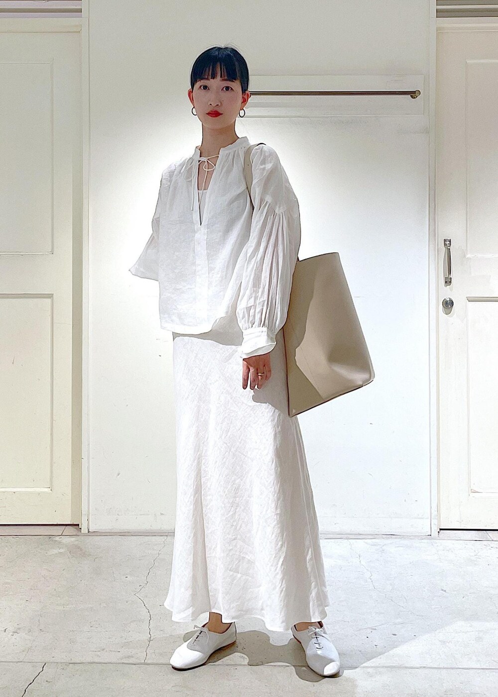 ホワイト系のその他シューズ、ホワイト系のシャツ/ブラウス、ベージュ系のトートバッグを着用したレディースの春コーディネートの3枚目の写真