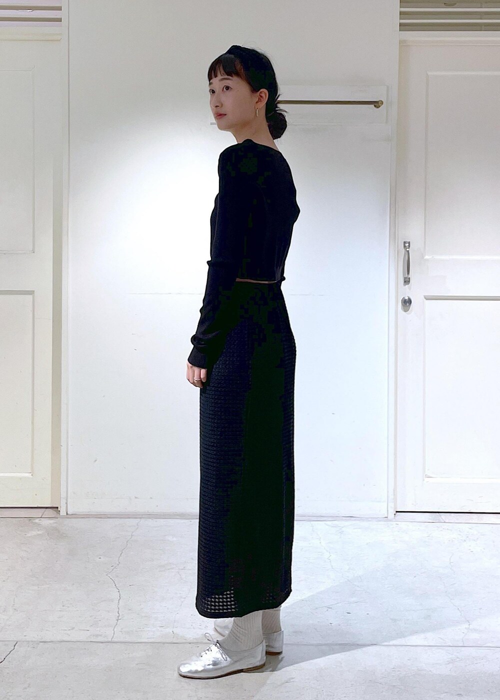 シルバー系のその他シューズ、ブラック系のスカート、ブラック系のカーディガン/ボレロを着用したレディースの冬コーディネートの2枚目の写真