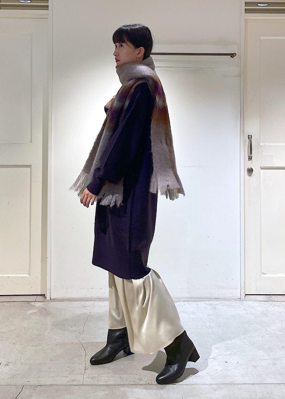 ブラック系のショルダーバッグ、ベージュ系のスカート、レッド系のワンピースを着用したレディースの秋コーディネートの8枚目の写真