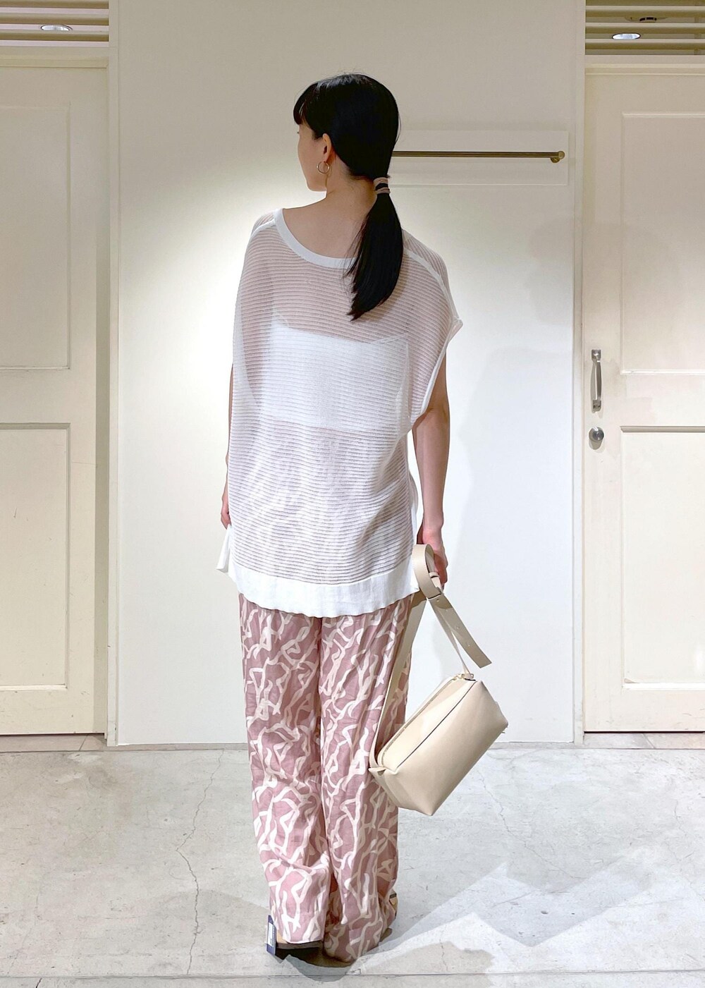 イエロー系のその他パンツ、ホワイト系のチューブトップ、ベージュ系のショルダーバッグを着用したレディースの夏コーディネートの3枚目の写真