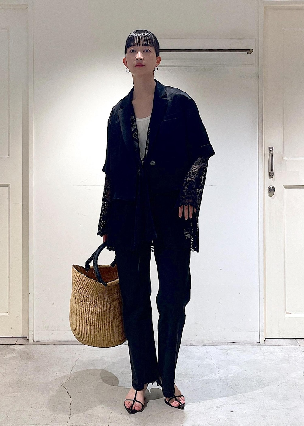 グレー系のデニムパンツ、ブラック系のノーカラージャケット、ブラック系のサンダルを着用したレディースの夏コーディネートの7枚目の写真