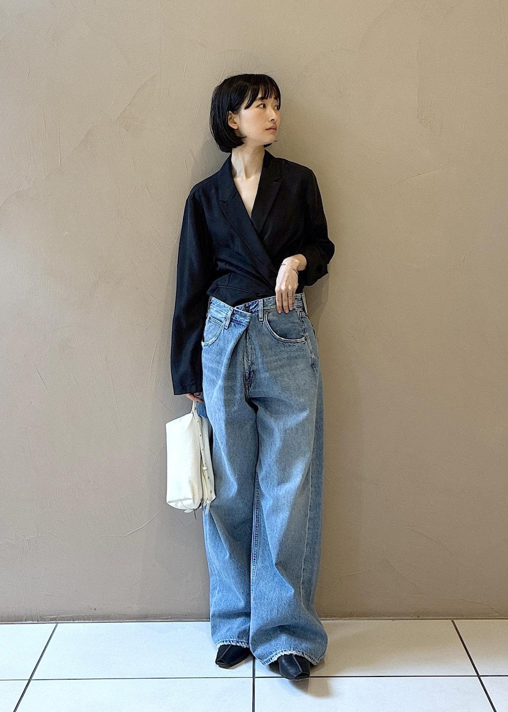 ブラック系のその他シューズ、ホワイト系のショルダーバッグ、ブラック系のテーラードジャケットを着用したレディースの春コーディネートの3枚目の写真