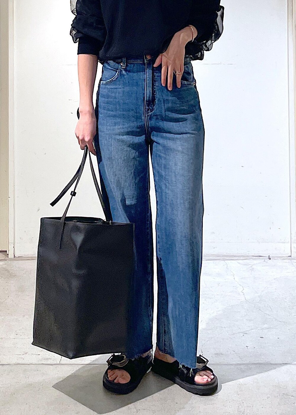 ブラック系のサンダル、ブラック系のトートバッグ、ブラック系のTシャツ/カットソーを着用したレディースの春コーディネートの3枚目の写真