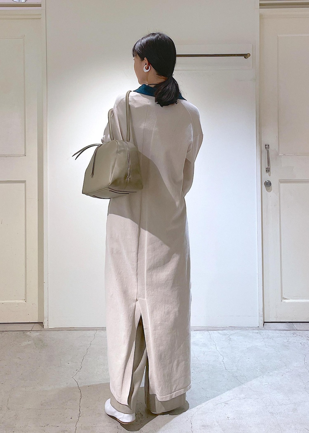 ホワイト系のその他シューズ、ベージュ系のスラックス、ホワイト系のチューブトップを着用したレディースの冬コーディネートの3枚目の写真