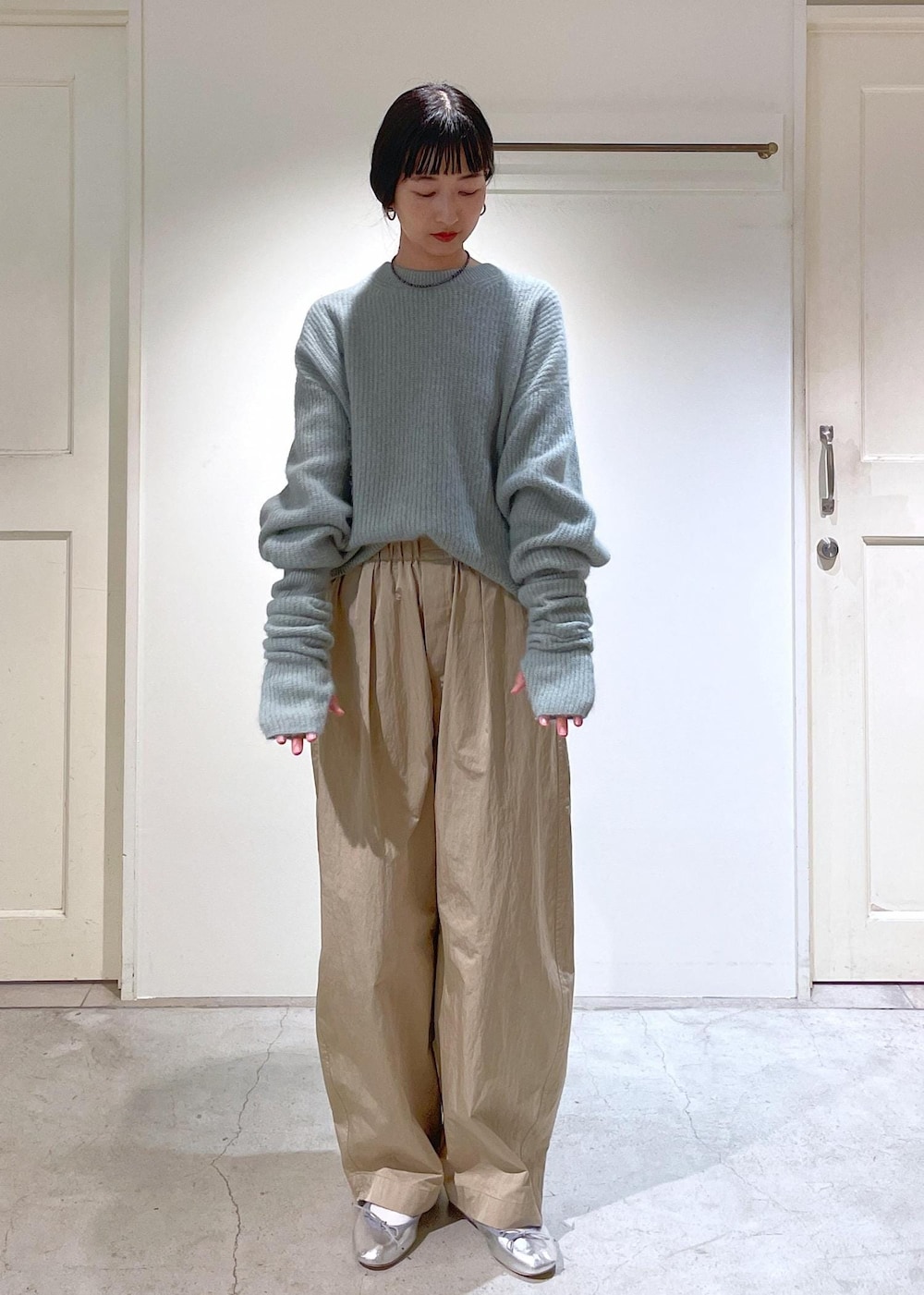 シルバー系のバレエシューズ、グレー系のショルダーバッグ、グリーン系のニット/セーターを着用したレディースの秋コーディネートの5枚目の写真