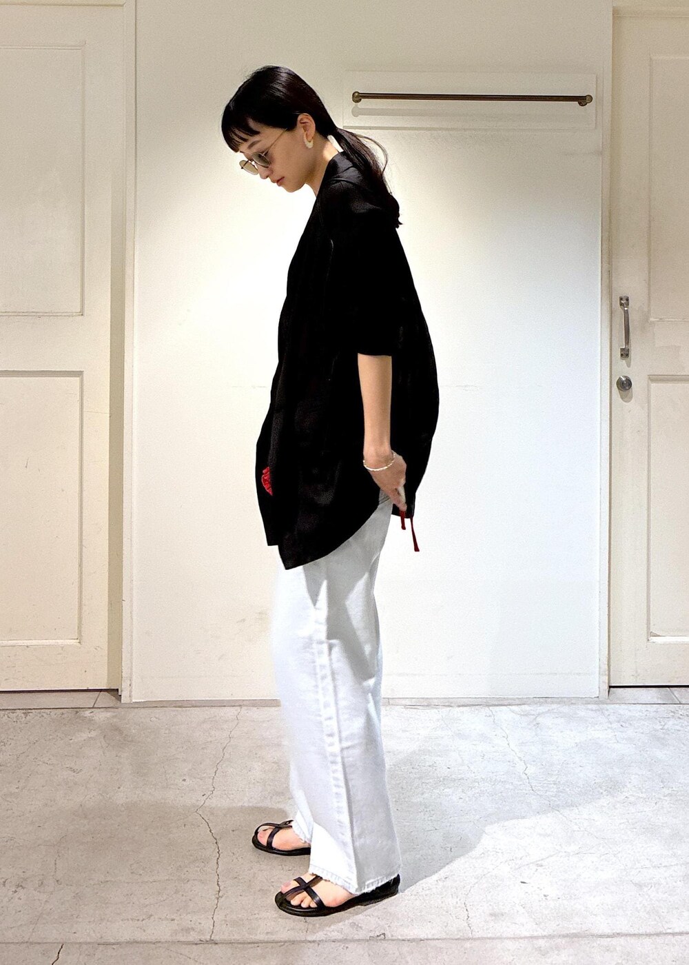 ブルー系のデニムパンツ、ブラック系のサンダル、グレー系のテーラードジャケットを着用したレディースの夏コーディネートの6枚目の写真