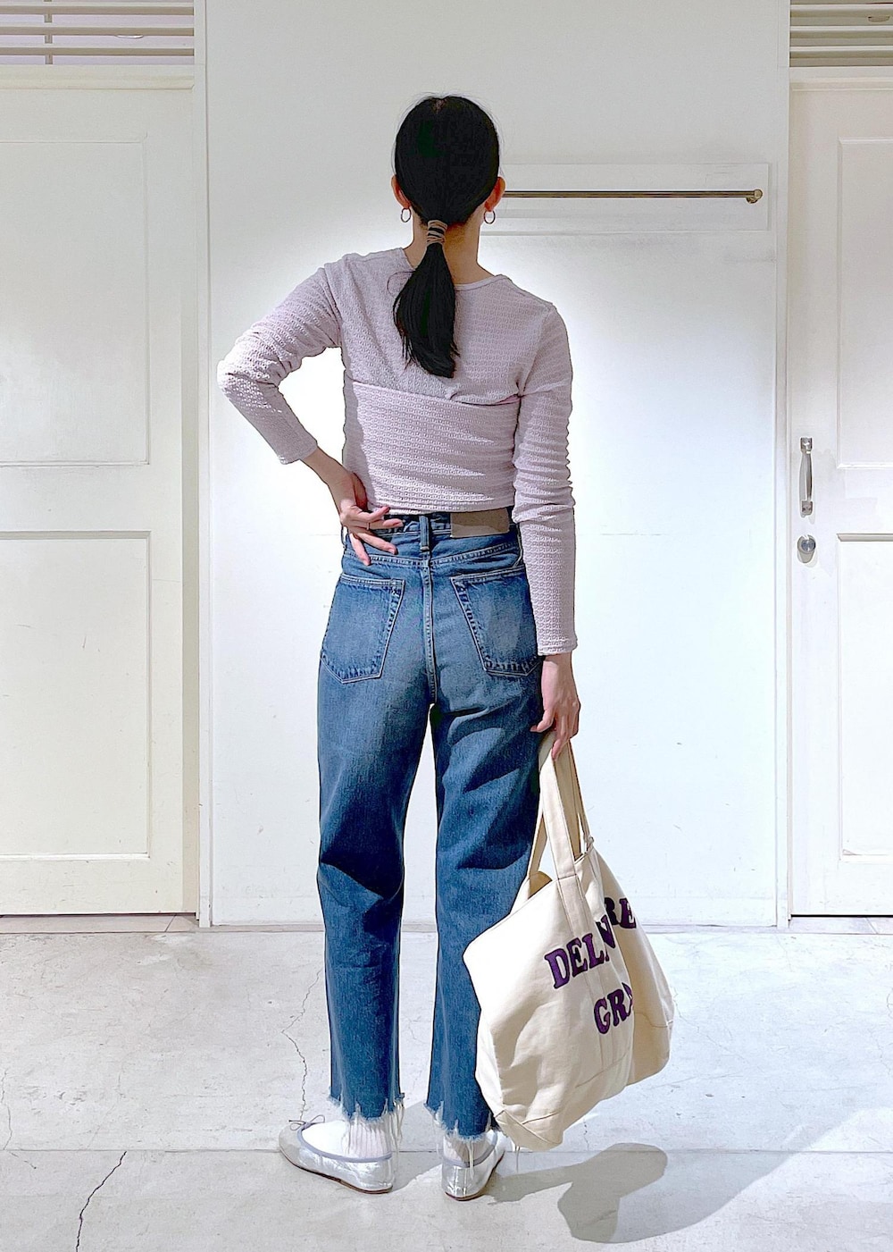 シルバー系のバレエシューズ、ブルー系のデニムパンツ、ピンク系のチューブトップを着用したレディースの春コーディネートの3枚目の写真