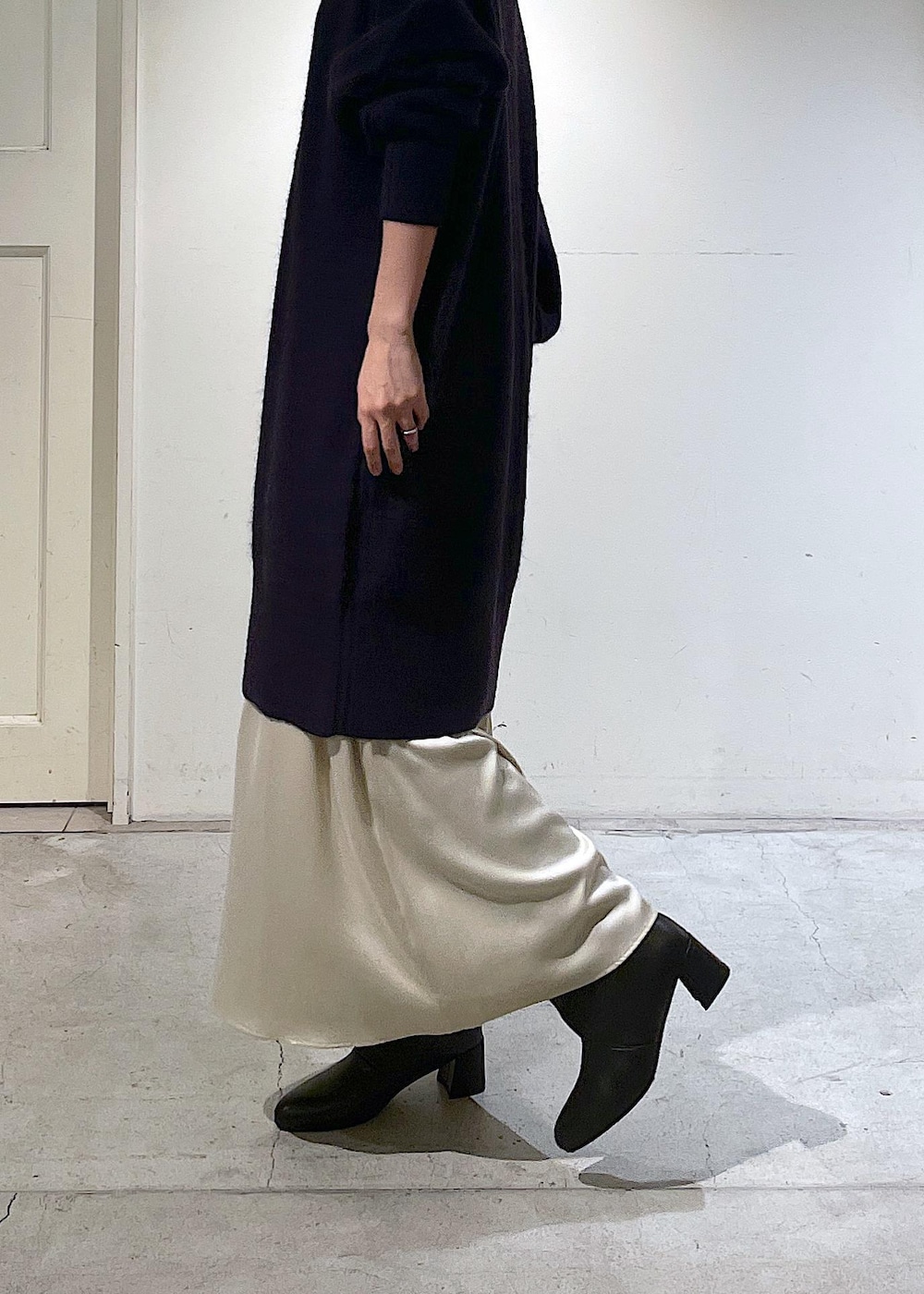 ブラック系のショルダーバッグ、ベージュ系のスカート、レッド系のワンピースを着用したレディースの秋コーディネートの7枚目の写真