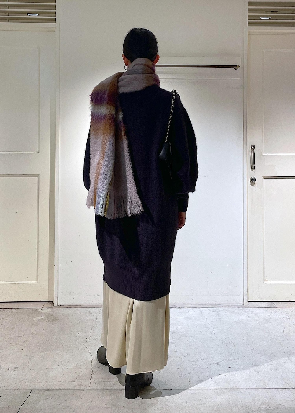 ブラック系のショルダーバッグ、ベージュ系のスカート、レッド系のワンピースを着用したレディースの秋コーディネートの5枚目の写真