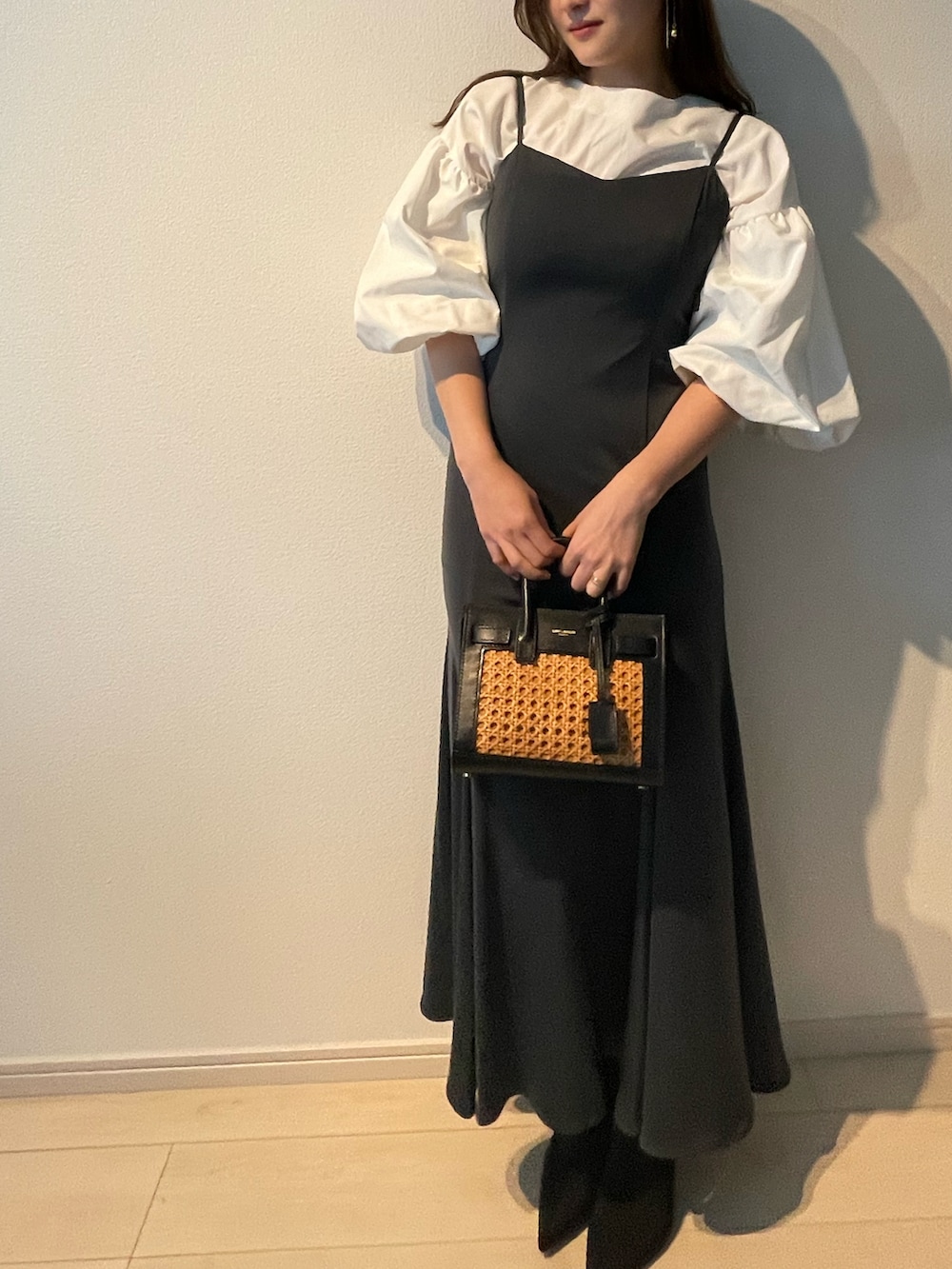 グレー系のドレス、ブラック系のブーツ、ブラック系のハンドバッグを着用したレディースの冬コーディネートの2枚目の写真