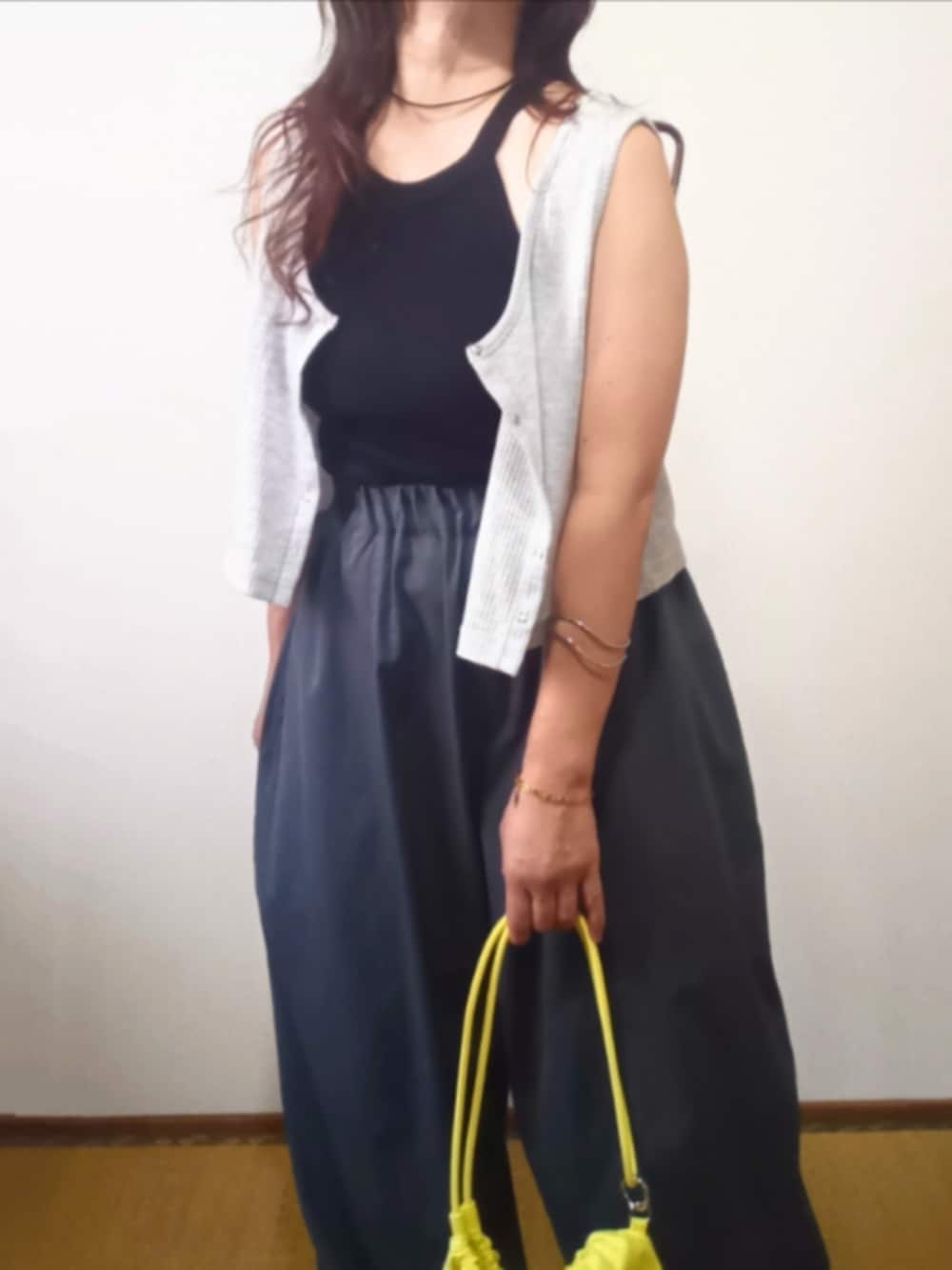 ブラック系のキャミソール、ベージュ系のTシャツ/カットソー、ブラック系のチノパンツを着用したレディースの夏コーディネートの2枚目の写真