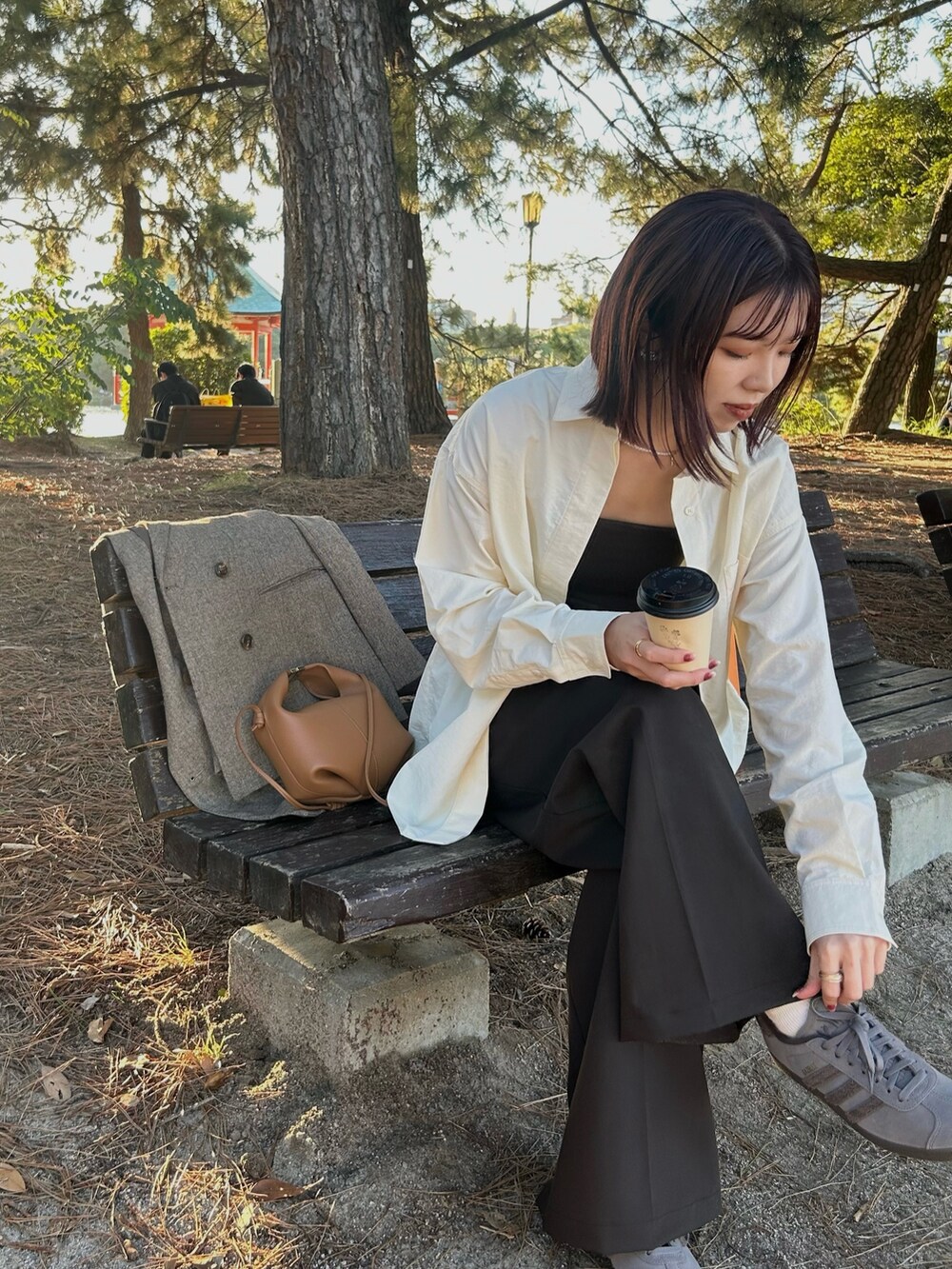 ホワイト系のシャツ/ブラウス、ブラウン系のキャミソールを着用したレディースの秋コーディネートの5枚目の写真