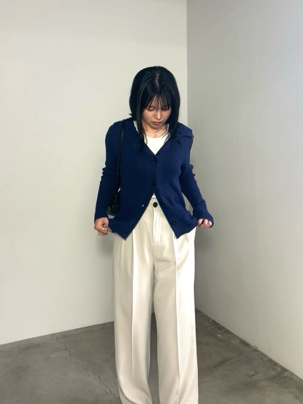 ブルー系のカーディガン/ボレロ、ホワイト系のスラックス、ブラック系のショルダーバッグを着用したレディースの冬コーディネートの4枚目の写真