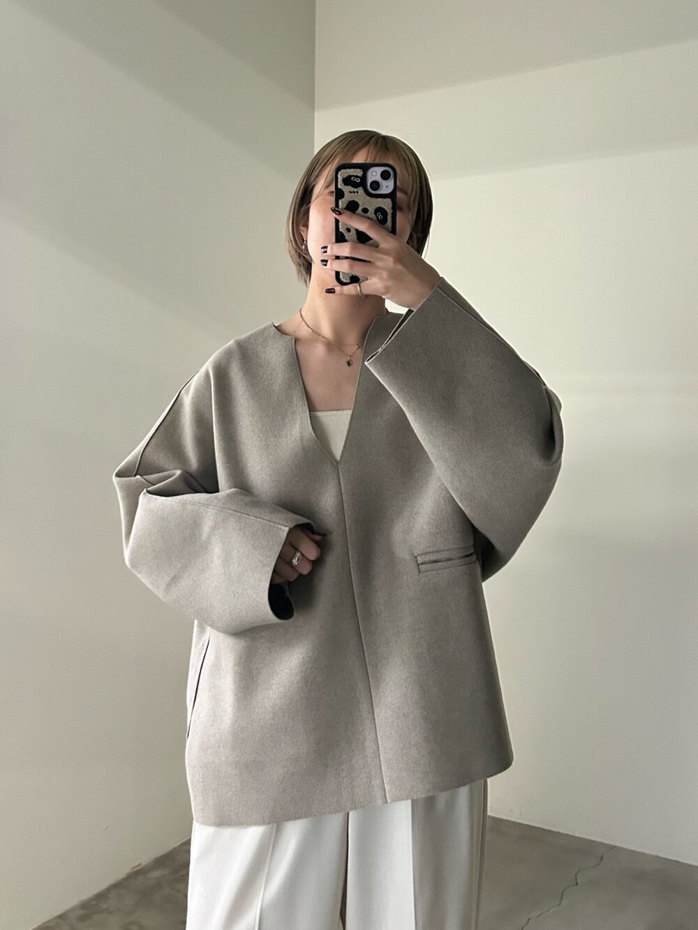 ホワイト系のスラックス、ホワイト系のキャミソール、ベージュ系のTシャツ/カットソーを着用したレディースの秋コーディネートの3枚目の写真