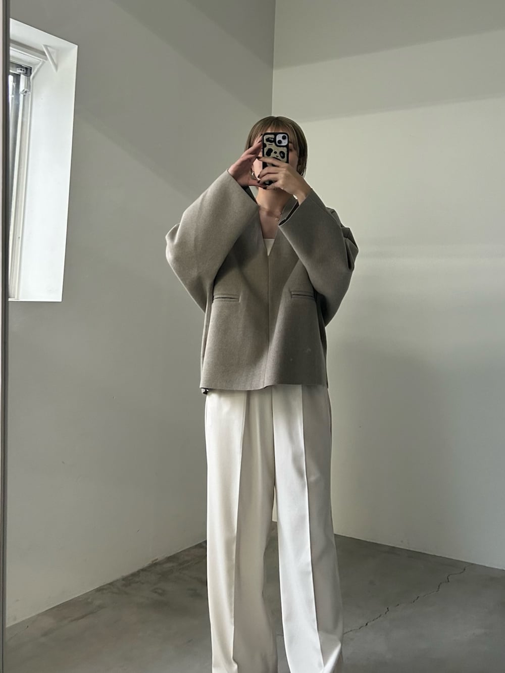 ホワイト系のスラックス、ホワイト系のキャミソール、ベージュ系のTシャツ/カットソーを着用したレディースの秋コーディネートの2枚目の写真