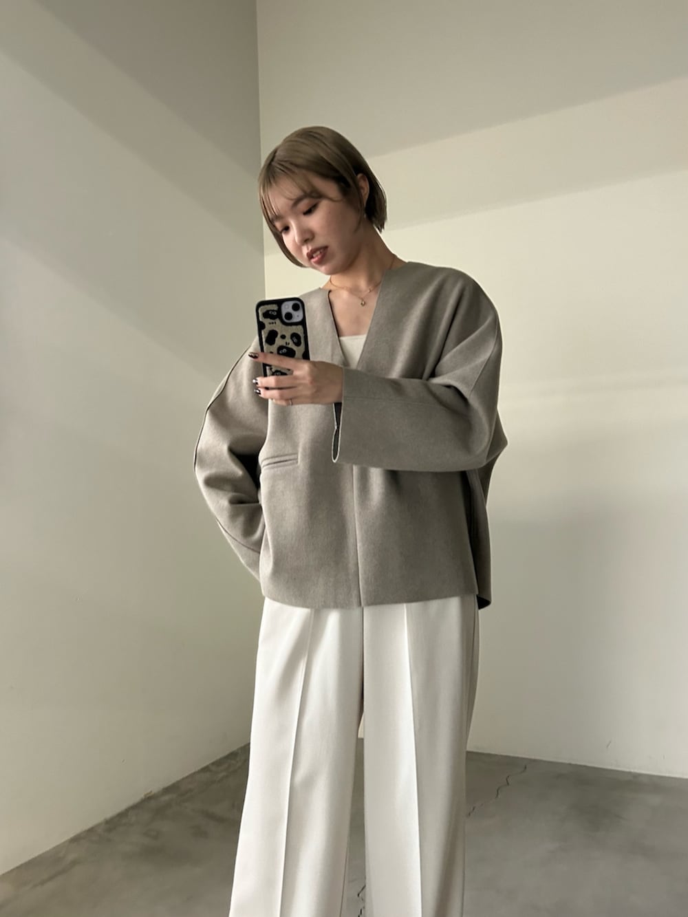 ホワイト系のスラックス、ホワイト系のキャミソール、ベージュ系のTシャツ/カットソーを着用したレディースの秋コーディネートの4枚目の写真