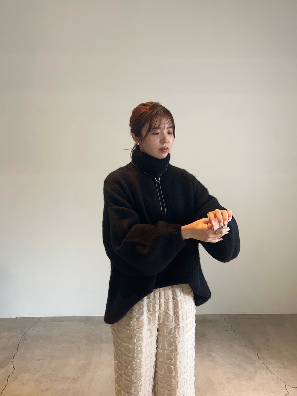 ブラック系のニット/セーター、ホワイト系のその他パンツ、シルバー系のネックレスを着用したレディースの秋コーディネートの5枚目の写真