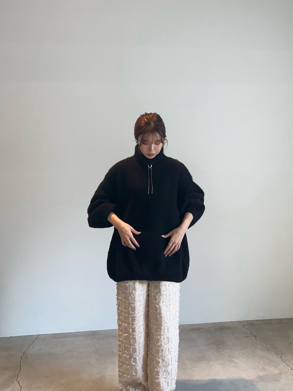 ブラック系のニット/セーター、ホワイト系のその他パンツ、シルバー系のネックレスを着用したレディースの秋コーディネートの2枚目の写真