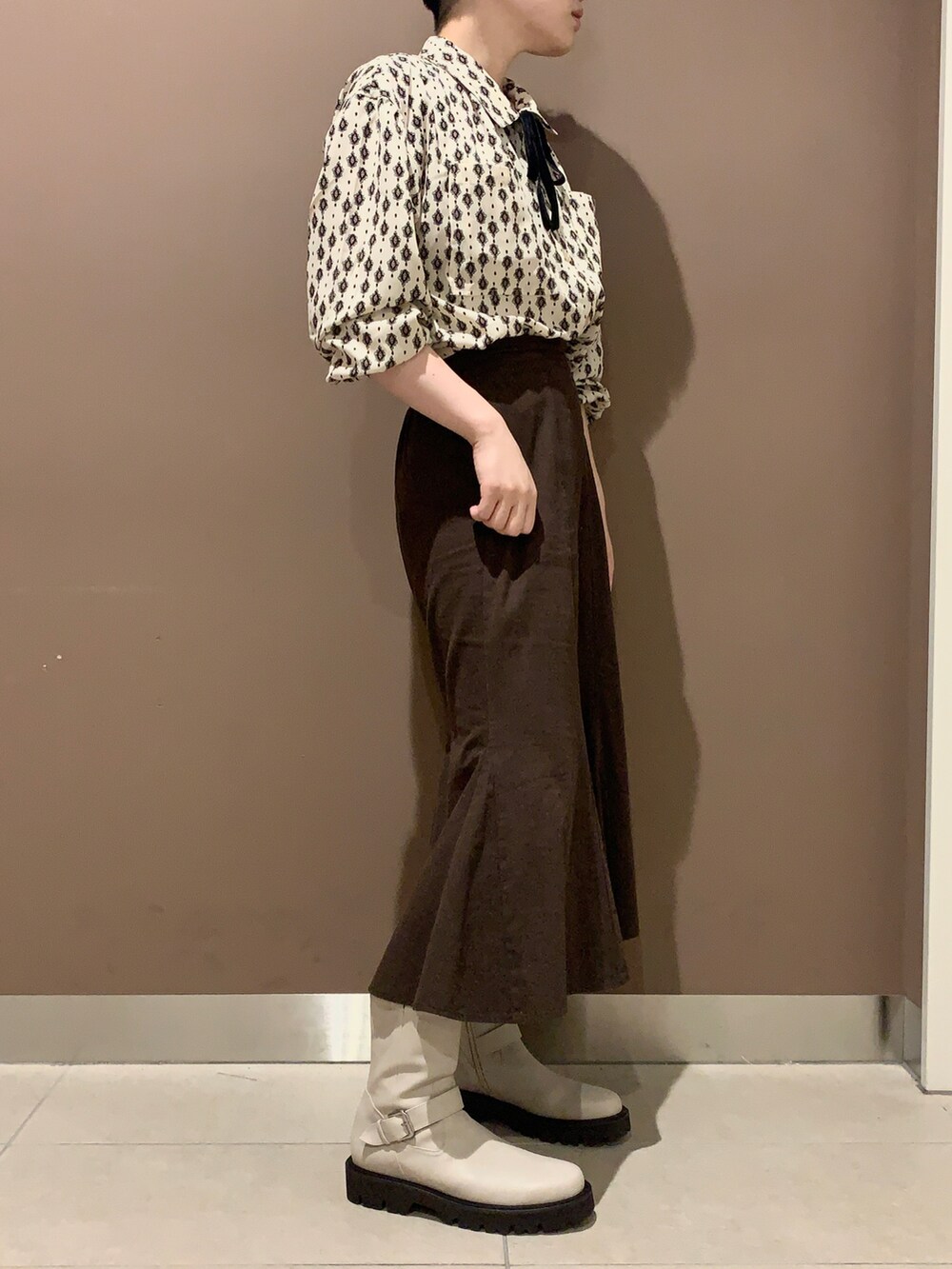 ホワイト系のブーツを着用したレディースの秋コーディネートの2枚目の写真