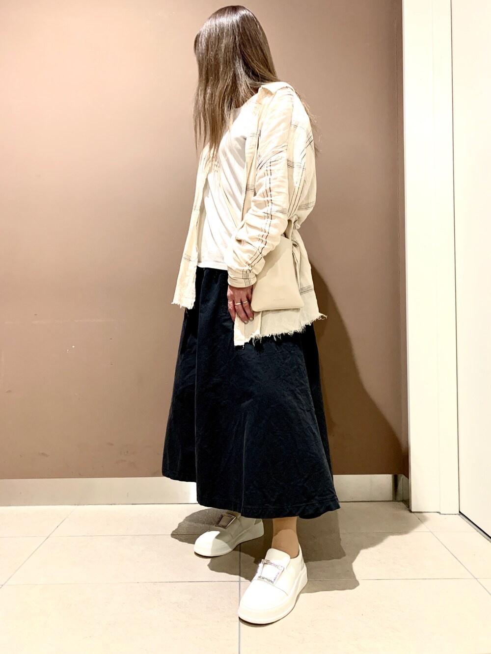 ホワイト系のスリッポンを着用したレディースの春コーディネートの2枚目の写真