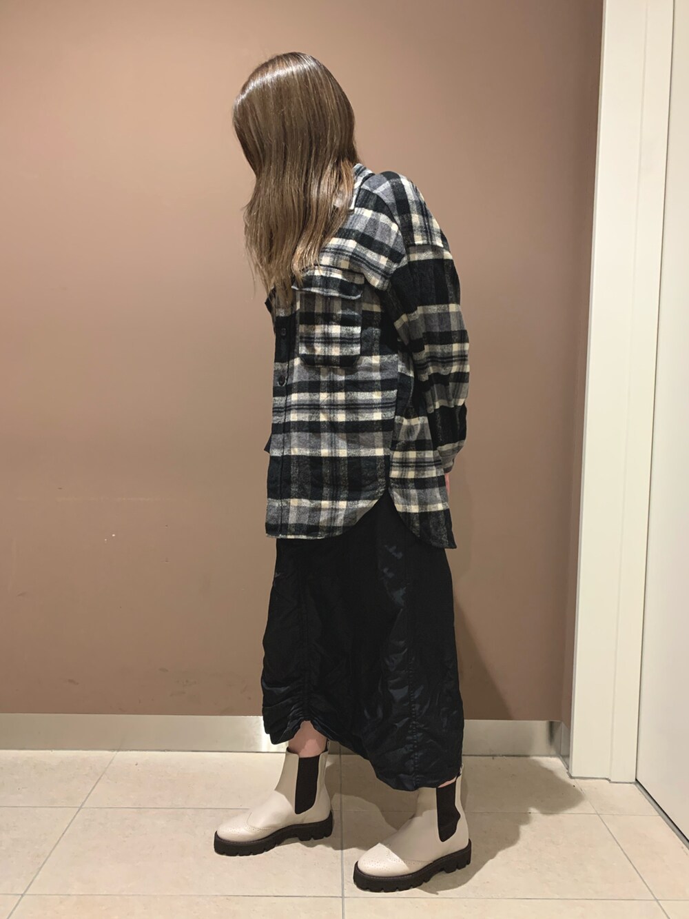 ホワイト系のブーツを着用したレディースの秋コーディネートの2枚目の写真