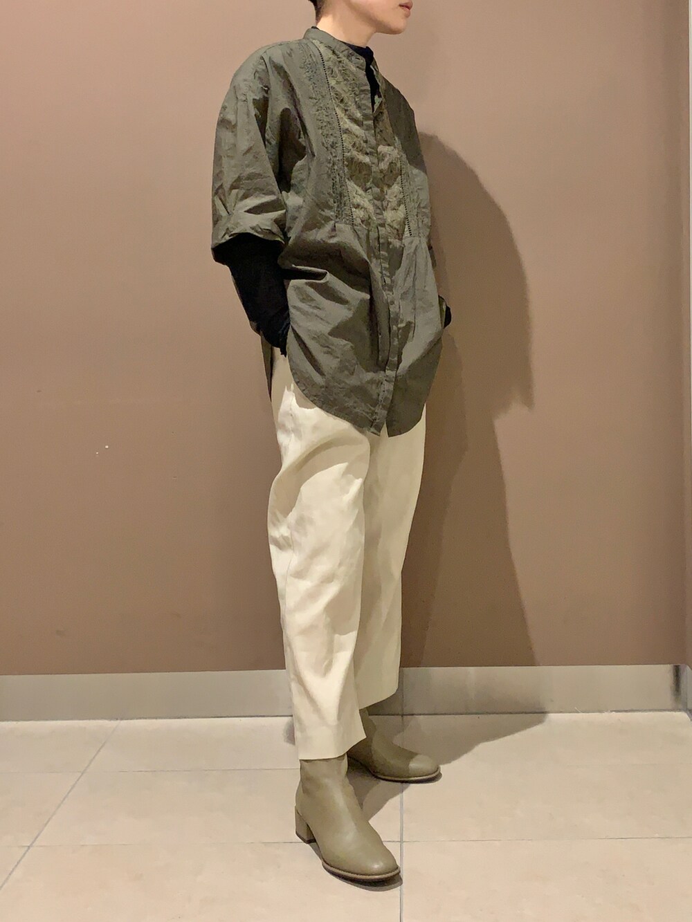 グレー系のブーツを着用したレディースの秋コーディネートの2枚目の写真