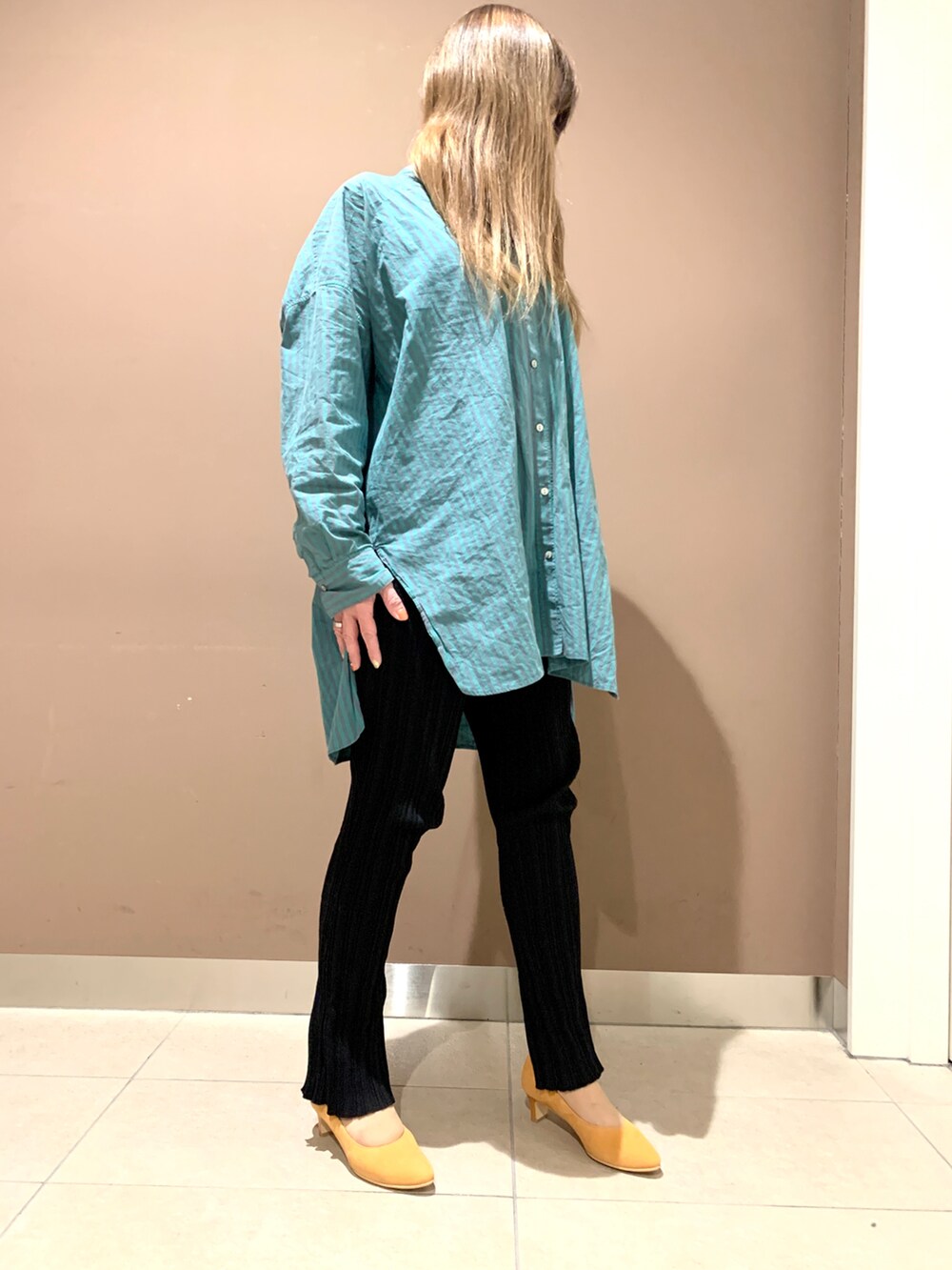 オレンジ系のパンプスを着用したレディースの春コーディネートの2枚目の写真