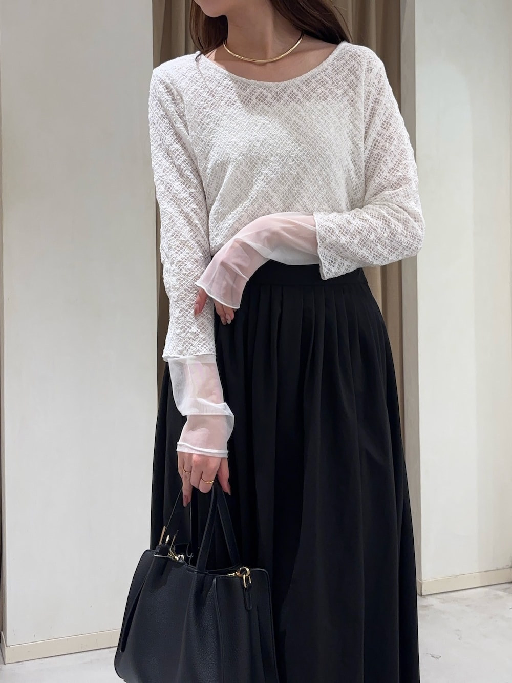 ホワイト系のTシャツ/カットソー、ホワイト系のスカート、ブラック系のトートバッグを着用したレディースの冬コーディネートの3枚目の写真
