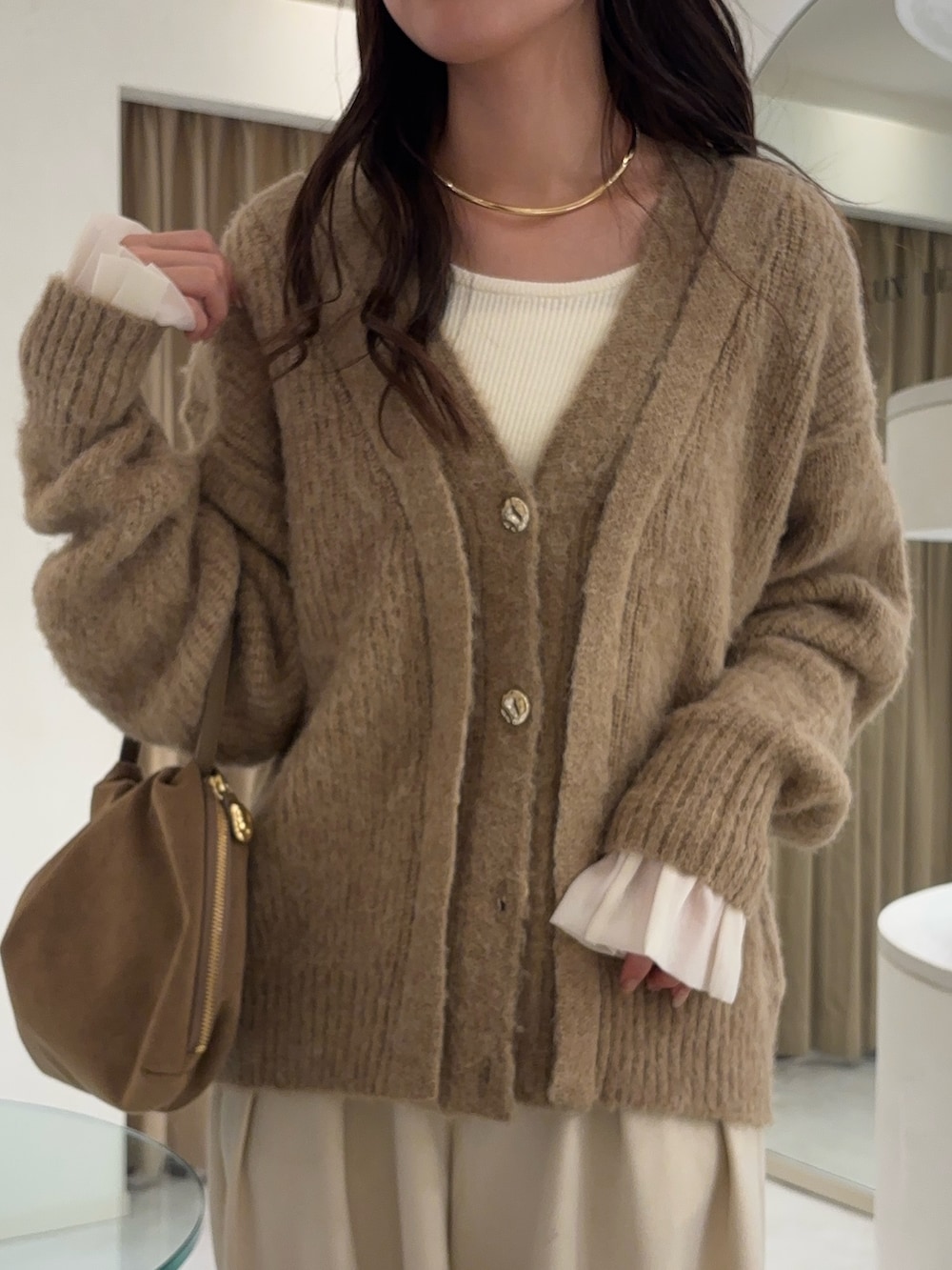 ベージュ系のカーディガン/ボレロ、ホワイト系のニット/セーター、イエロー系のショルダーバッグを着用したレディースの秋コーディネートの3枚目の写真