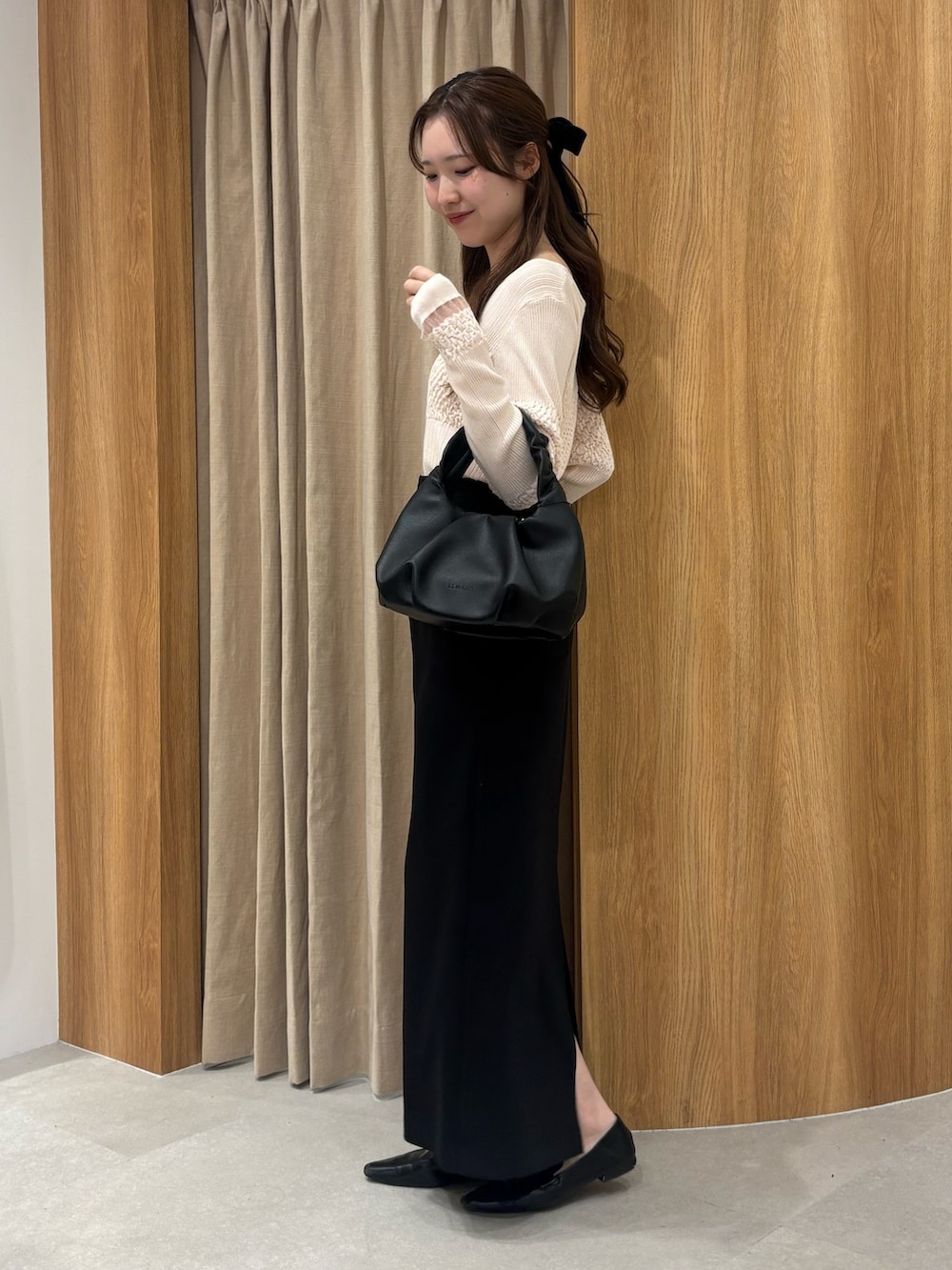 ピンク系のニット/セーター、ベージュ系のショルダーバッグ、ホワイト系のスカートを着用したレディースの春コーディネートの2枚目の写真