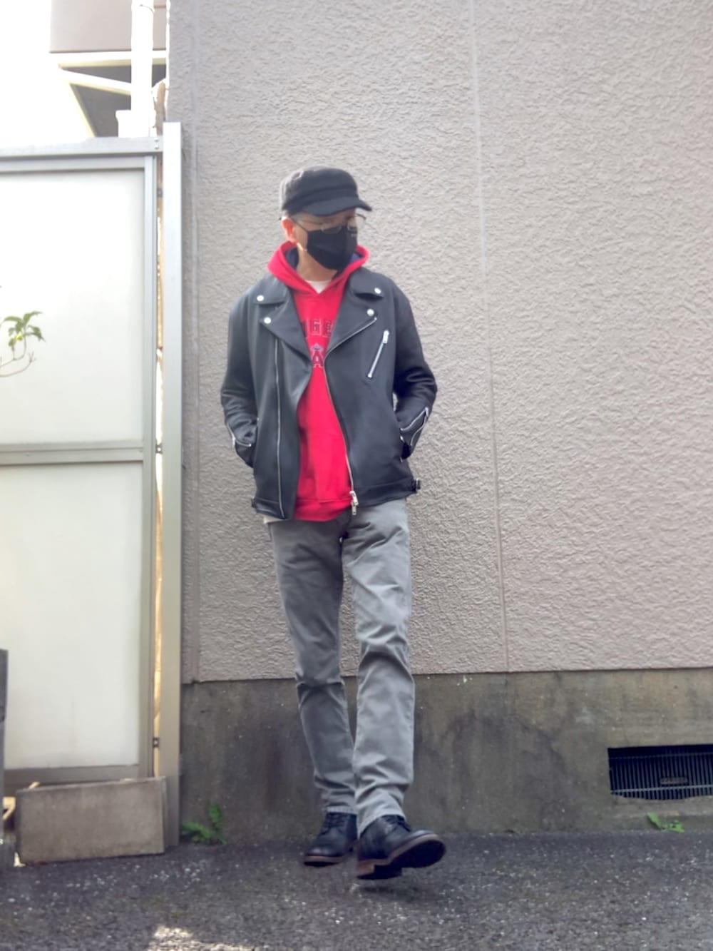 ブラック系のライダースジャケット、グレー系のデニムパンツ、レッド系のパーカーを着用したメンズの秋コーディネートの3枚目の写真