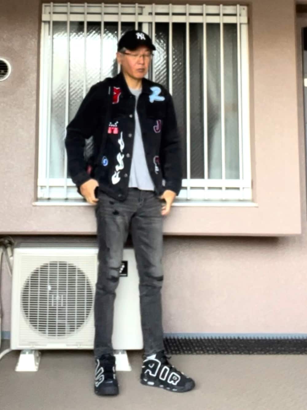 ブラック系のデニムジャケット、ブラック系のパンツ、ブラック系のスニーカーを着用したメンズの秋コーディネートの2枚目の写真