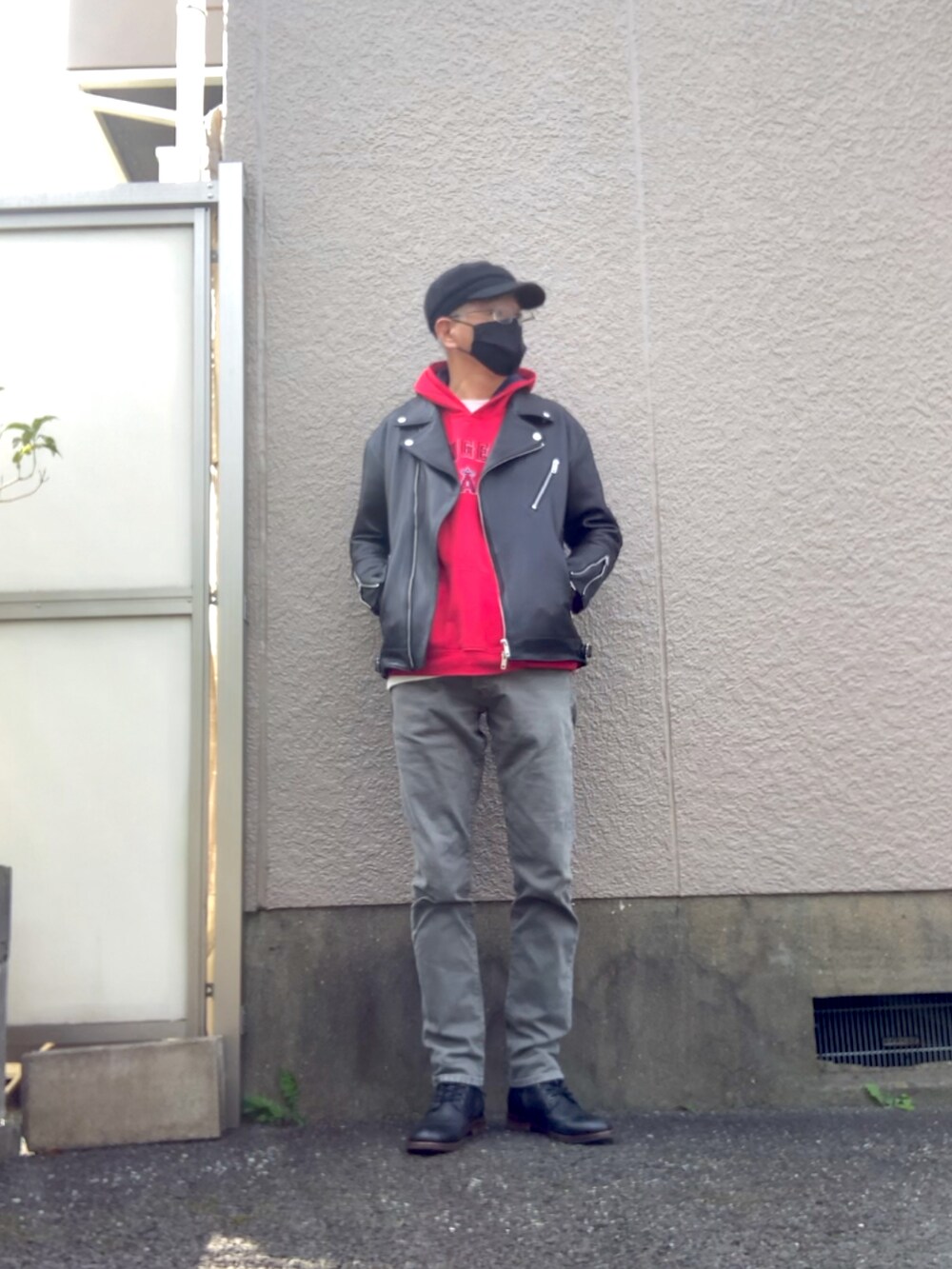 ブラック系のライダースジャケット、グレー系のデニムパンツ、レッド系のパーカーを着用したメンズの秋コーディネートの4枚目の写真