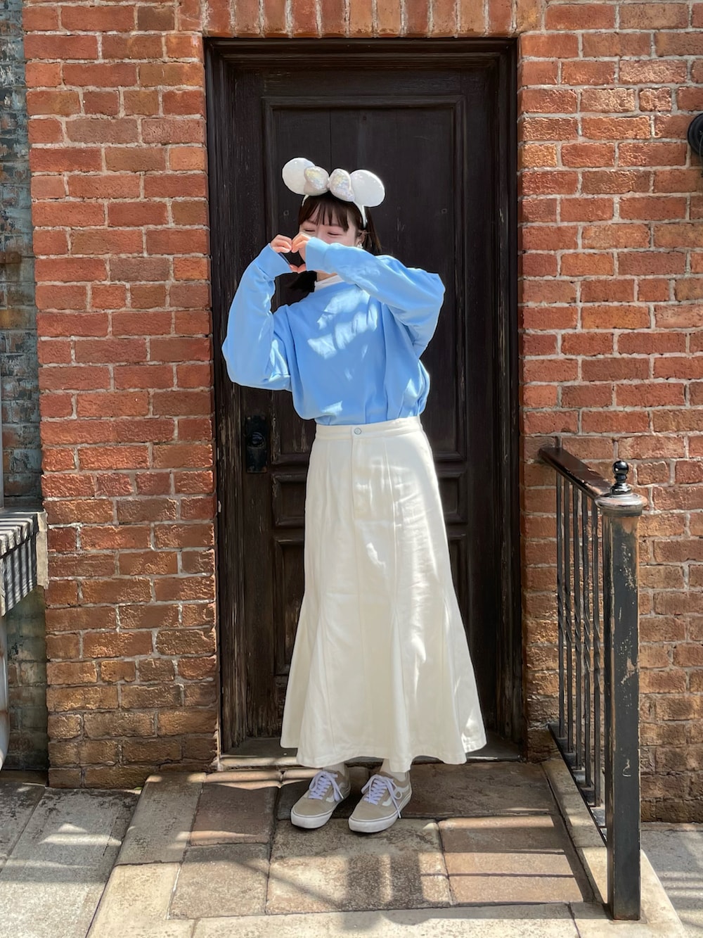 ブルー系のTシャツ/カットソー、ホワイト系のスカート、ベージュ系のスニーカーを着用したレディースの春コーディネートの2枚目の写真