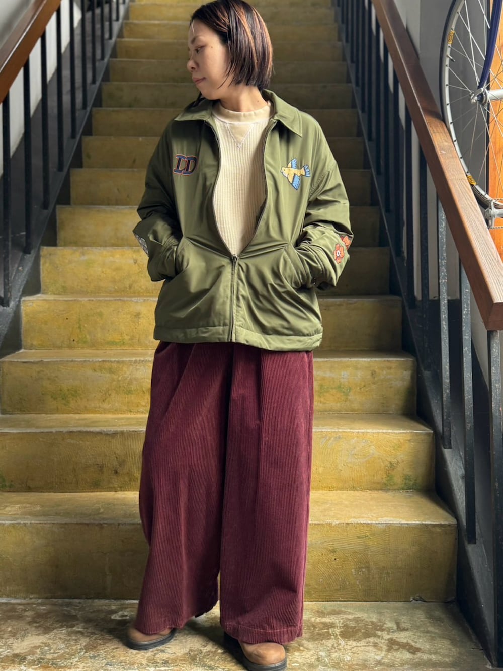 グリーン系のブルゾン、ブラウン系のその他パンツを着用したレディースの秋コーディネートの2枚目の写真