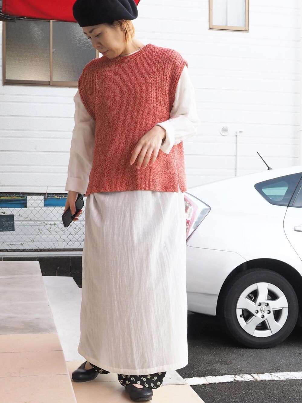 ブラック系のベスト、ホワイト系のワンピース、ブラック系のその他パンツを着用したレディースの冬コーディネートの2枚目の写真