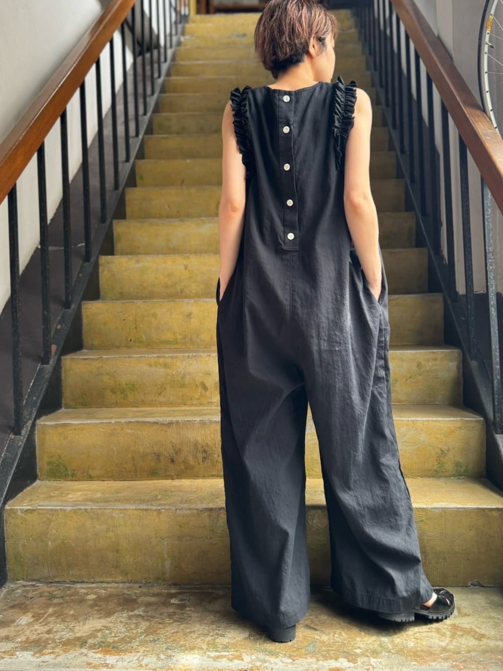 ブラック系のつなぎ/オールインワンを着用したレディースの夏コーディネートの2枚目の写真